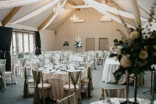 Wide view of the reception setup at Blackwell Grange, featuring floral centrepieces and elegant table arrangements by a wedding florist in the Cotswolds.