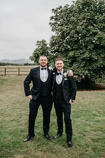 The groom and his groomsman posing outdoors with a scenic countryside backdrop at Blackwell Grange.